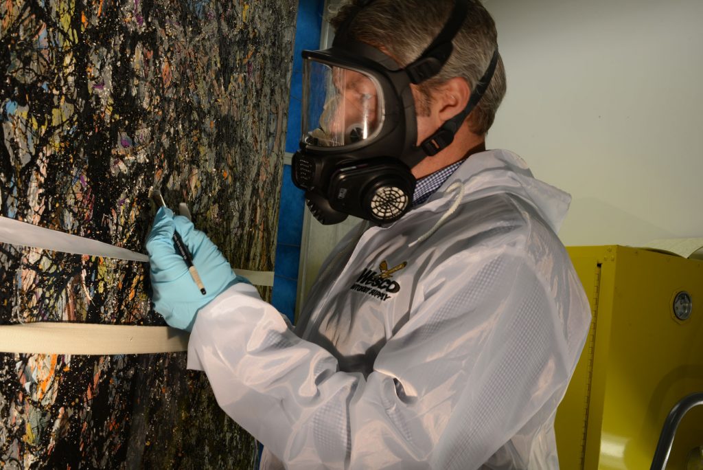 SAM Chief Conservator Nick Dorman removing varnish on Sea Change.